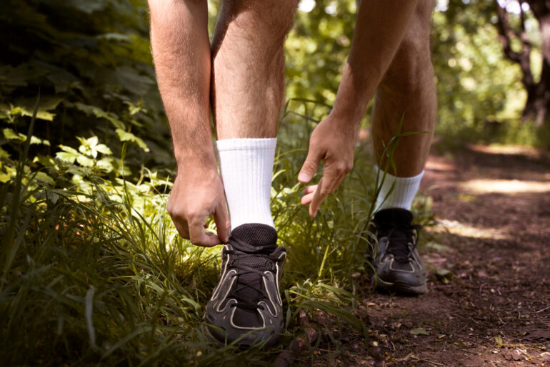 man tying shoelaces while out for a run