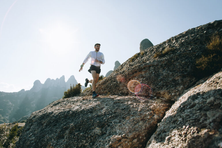 Man running over mountain rocks